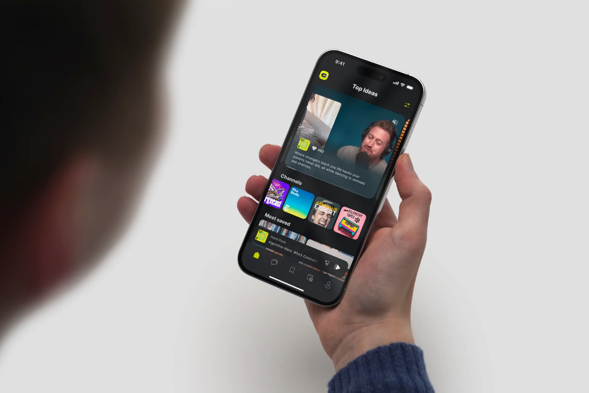 CueUp Top Ideas feed on an iPhone held in hand, with a clip, quote, and channel row