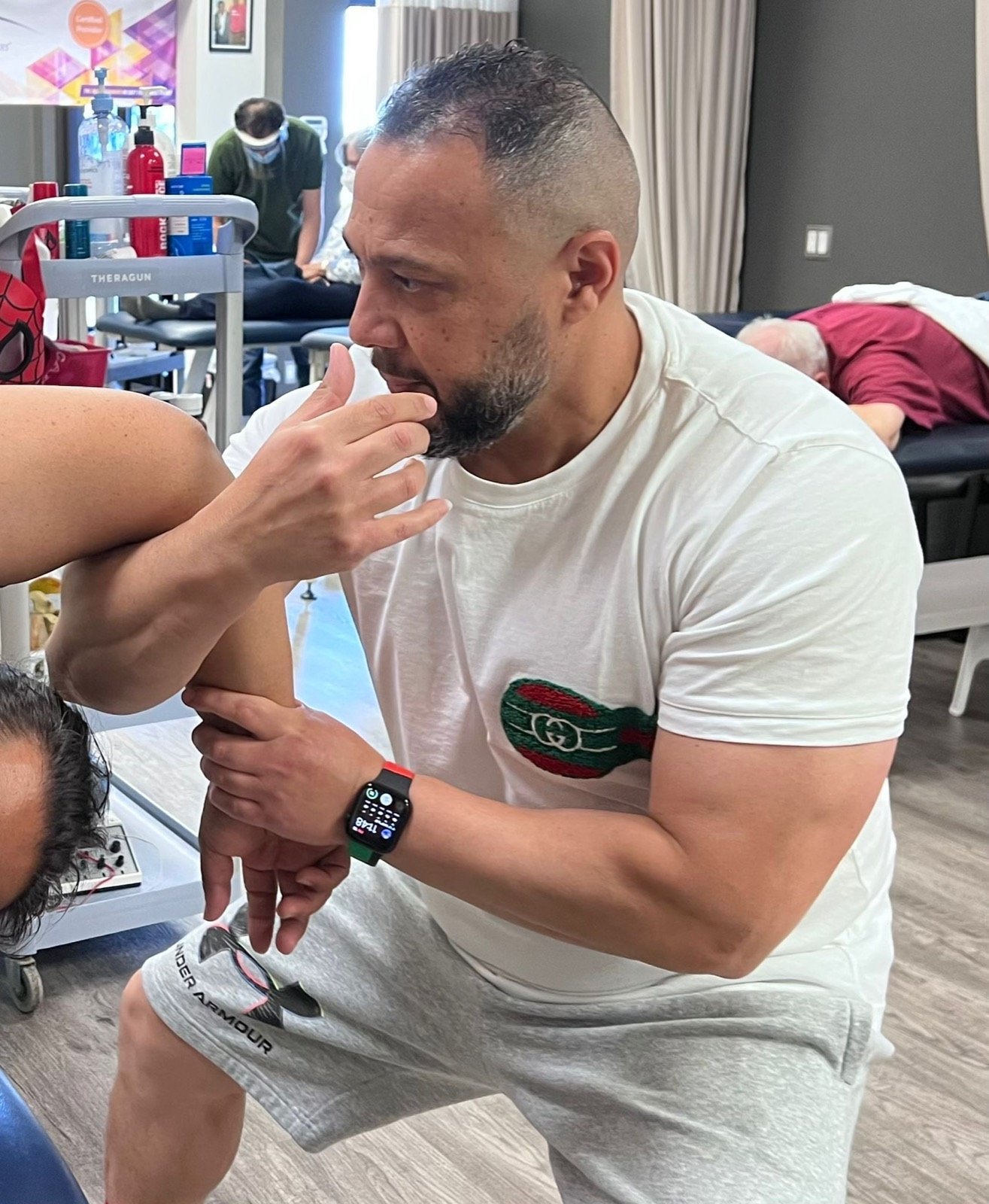Ghassan assessing a patient's shoulder and elbow